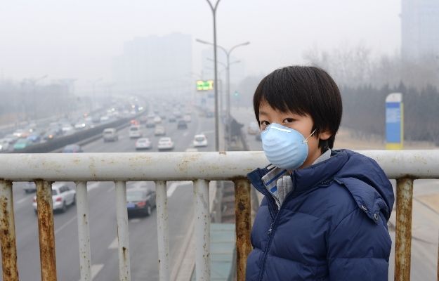 young boy wearing a mask in a city filled with smoke and air pollution - Which Type of Environment Affects Genes the Most | How The Environment You Grew Up In Can Have Long Term Effect On Genes