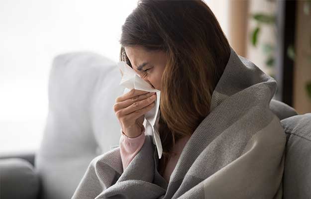 young-woman-sitting-on-sofa-covered-with-blanket--ss-body | Fighting Viral Infections with Epigenetics