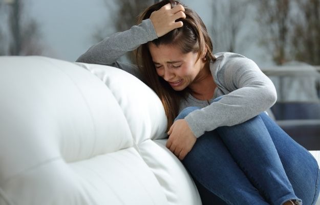 a girl is being depressed sitting on the sofa | Anxiety Disorders (ADs) Scope | Epigenetics and Anxiety - The Relationship Between Genes and Stress-Related Disorders